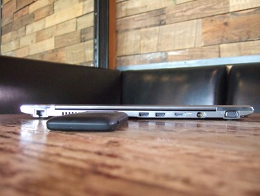 picture of closed laptop with a small black device next to it