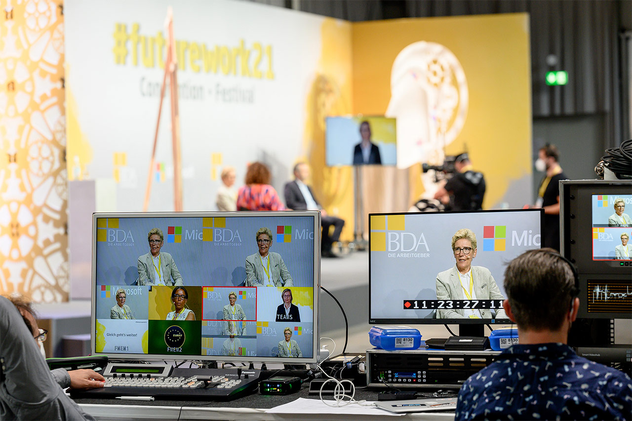 Das Foto zeigt Bildschirme zur Übertragung der vergangenen Veranstaltung zur #futurework