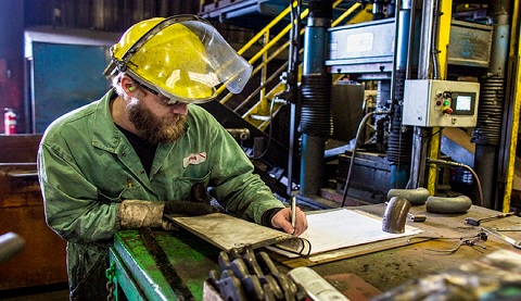 Ein Mann im Overall mit einem gelben Schutzhelm