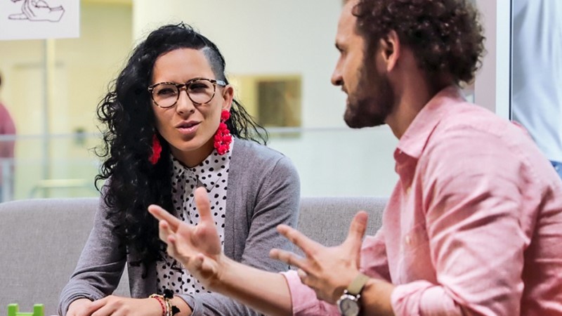 Zwei Firmenmitarbeiter, ein Mann und eine Frau, im Gespräch