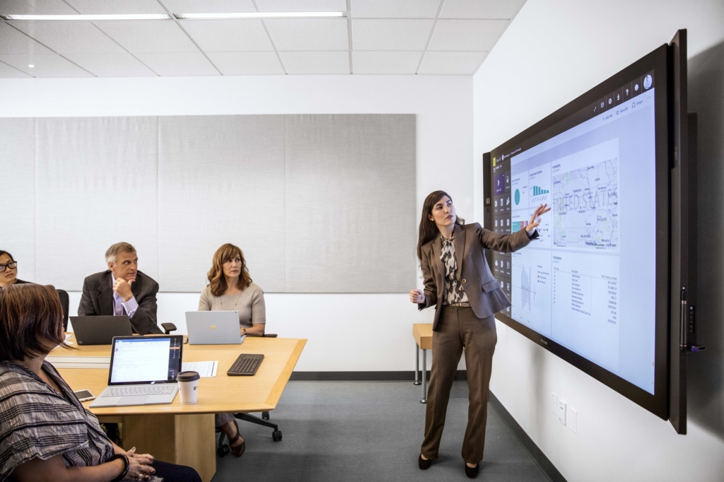 Eine Geschäftsfrau im Business-Look präsentiert in einem Konferenzsaal über HPC.