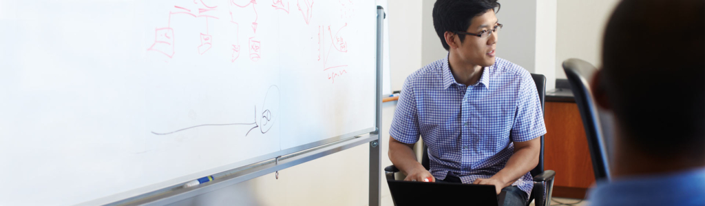 Ein junger Mann im Krankenhaus arbeitet an einem Laptop