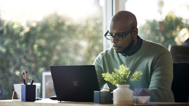 Ein Mann arbeitet zu Hause auf dem Surface Laptop 2.