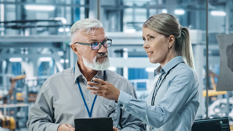 Mann und Frau in einer Produktionshalle. 