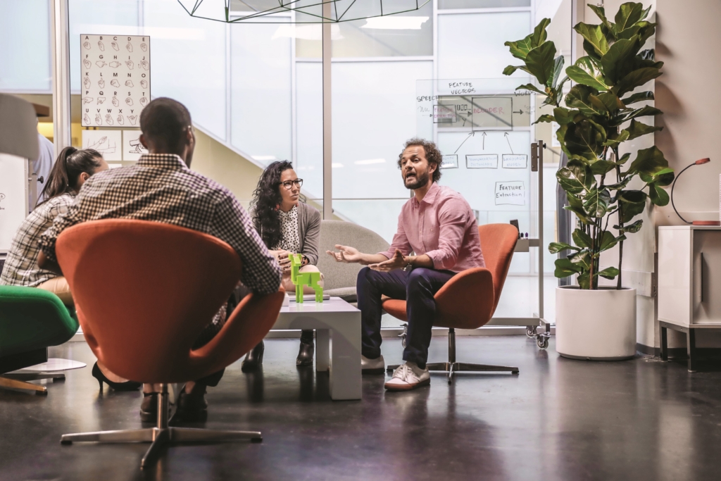 Zwei Männer und zwei Frauen diskutieren Ideen in einem Büro