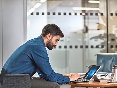 Ein Mann im Sessel arbeitet an einem Surface Device Ein Mann im Sessel arbeitet an einem Surface Devic