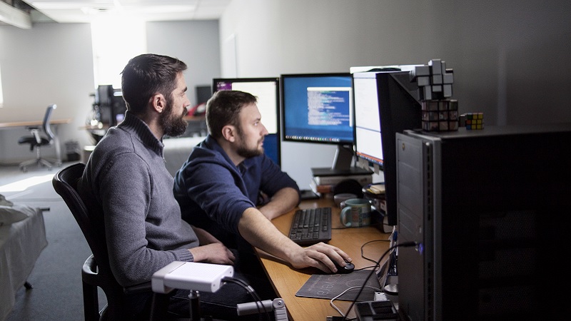 Zwei Programmierer im Gespr&auml;ch bei der Arbeit