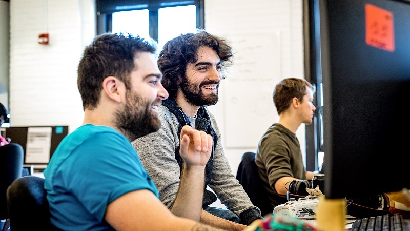Zwei M&auml;nner bei der Teamarbeit an einem Computer