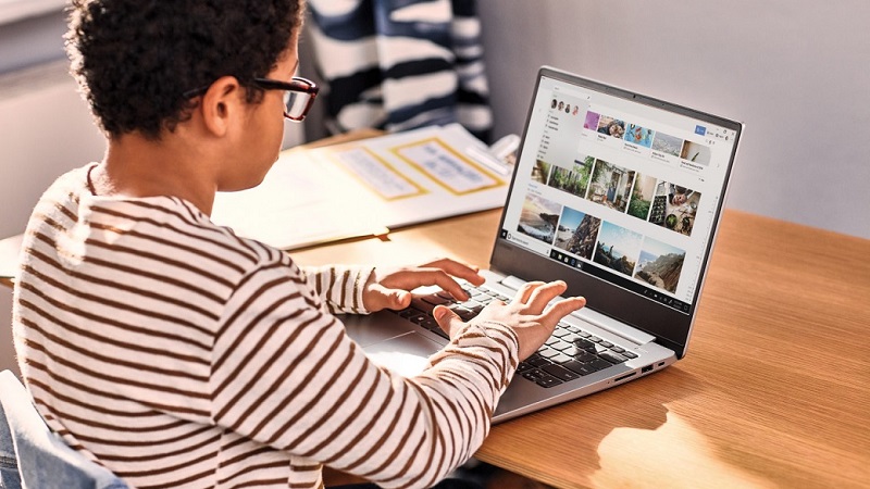 Ein Kind sitzt mit dem R&uuml;cken zur Kamera und arbeitet an einem Surface Device