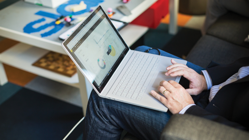 Ein Mann arbeitet mit seinem Laptop auf dem Schoß