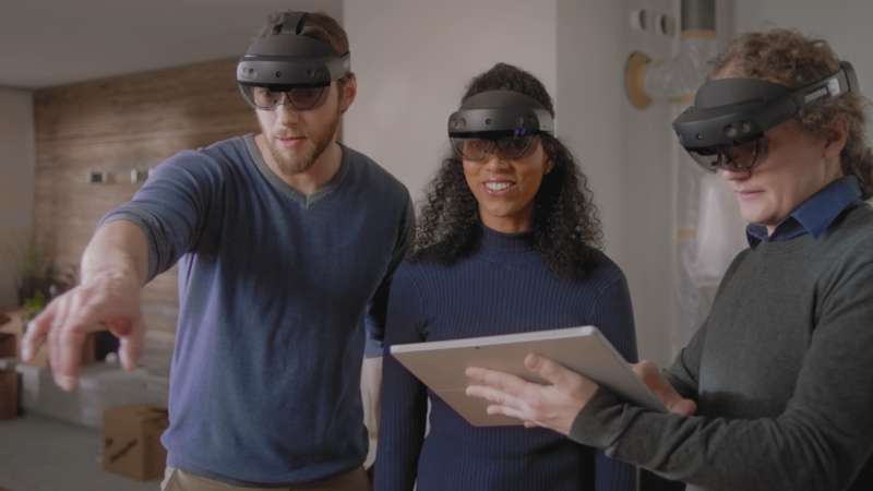 Drei Personen mit einer Microsoft HoloLens 2 schauen sich in einem virtuellen Raum um