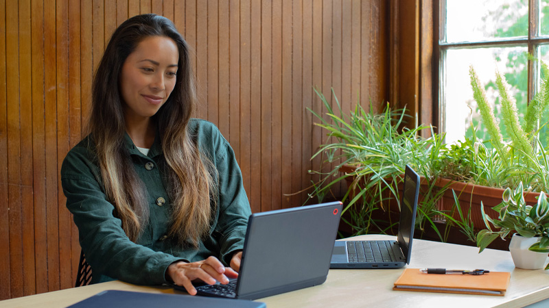 Eine junge Frau sitzt am Laptop
