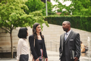 a group of people standing next to a man in a suit and tie