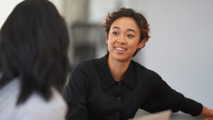 A woman smiling at another woman