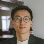 A man wearing glasses and a suit