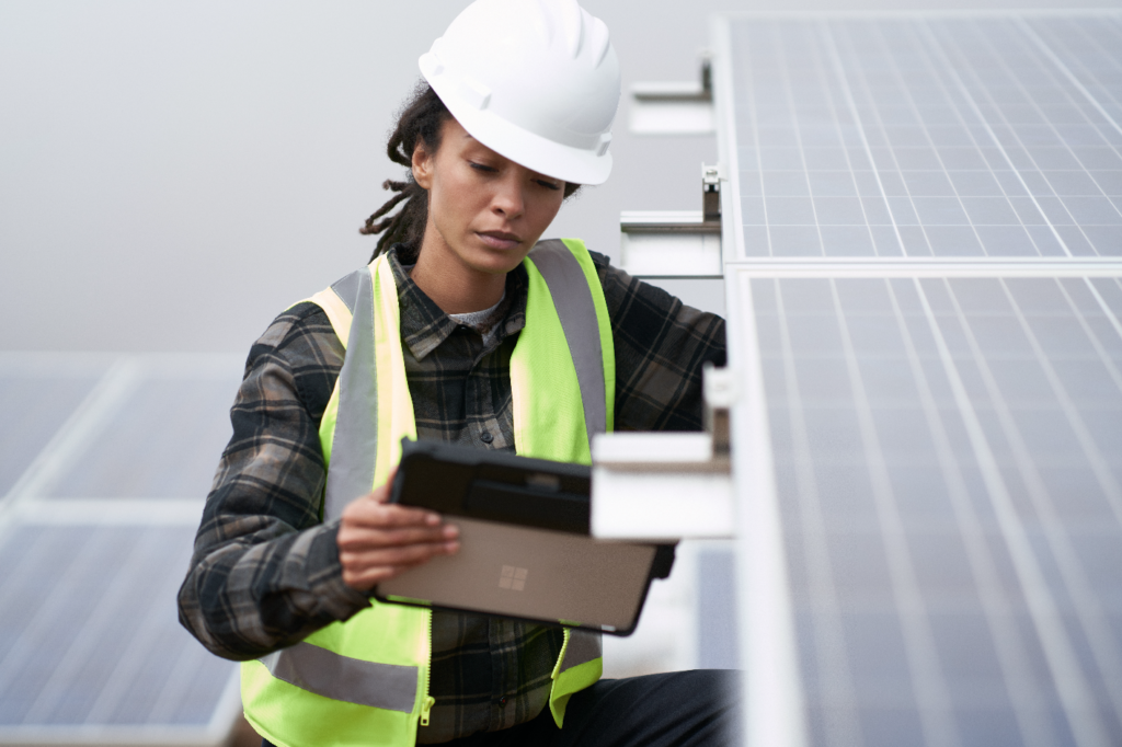 Person with tablet next to solar panels