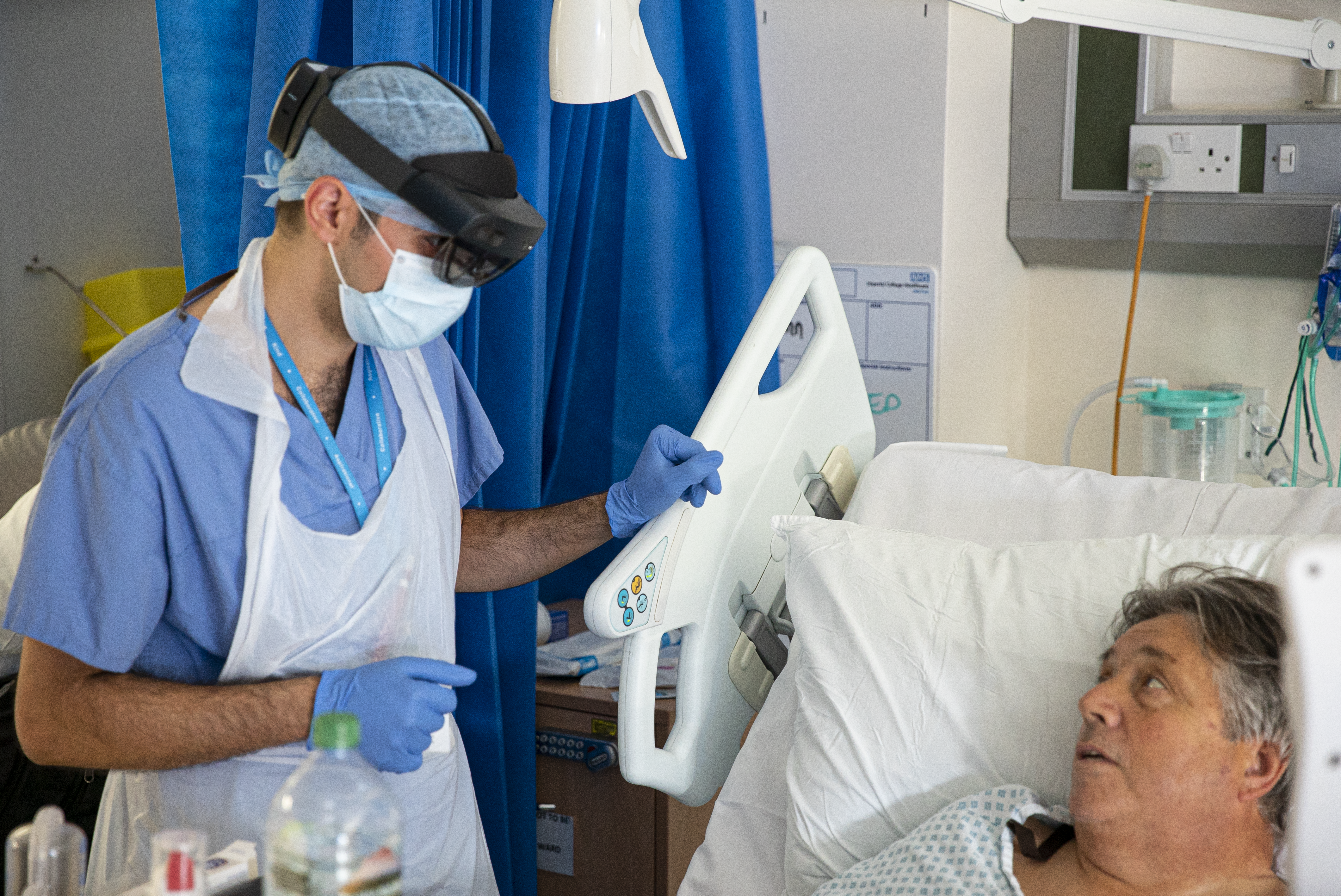 An NHS doctor at St. Mary&rsquo;s Hospital speaks with a patient on a COVID-19 ward during the pandemic whilst wearing a Microsoft HoloLens 2