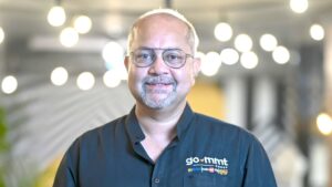 A man with glasses wearing a blue buttoned down shirt