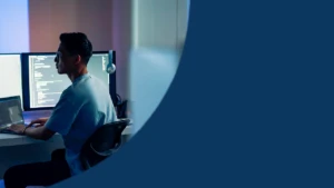 A security practitioner works at a computer.