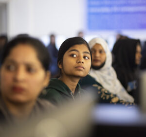 Women in a lecture hall looking at what is being presented