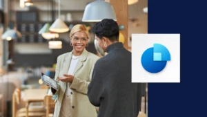 A business owner looking at a tablet next to the Dynamics 356 Sales logo