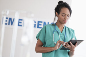Nurse using a tablet for documentation in an emergency department.