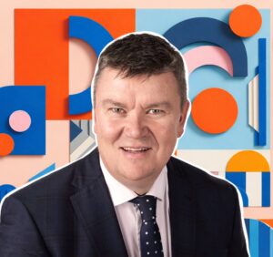 Man in a business suit with colorful shapes in the background.