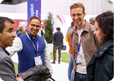 Three individuals engaged in conversation at a social event, exchanging ideas and smiles.