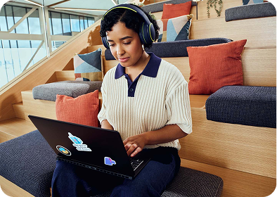 A woman wearing headphones, focused on listening, with a serene expression on her face.