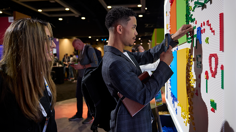 A woman sitting on a couch, focused on her laptop, with a cozy living room setting in the background.