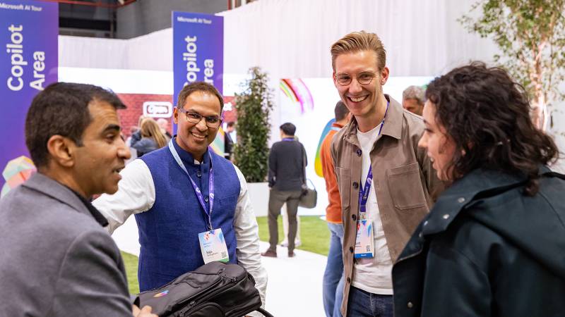 Four individuals engaged in conversation at a lively event.
