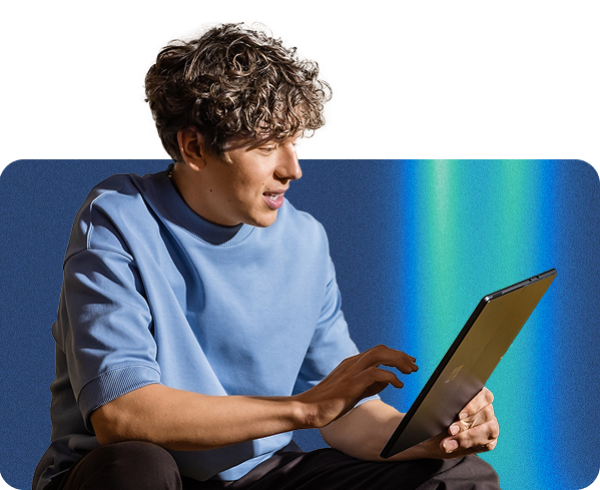A man seated on a chair, appearing calm and thoughtful in a casual setting.