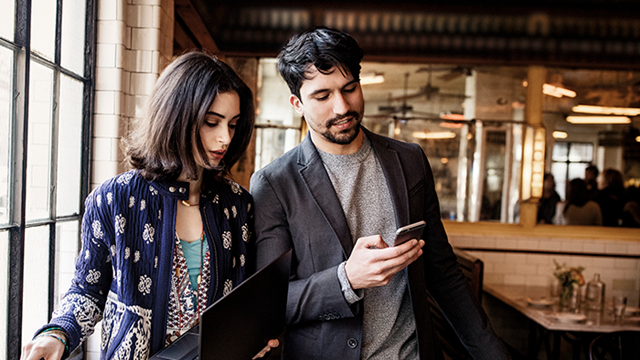 Featured image shows two people using devices in a restaurant, to show the mobility of the new Planner mobile app