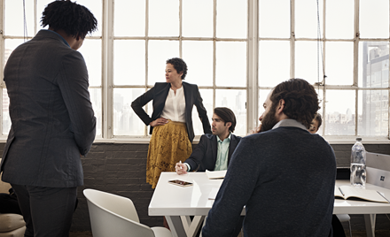 A group meets around a table in a meeting room