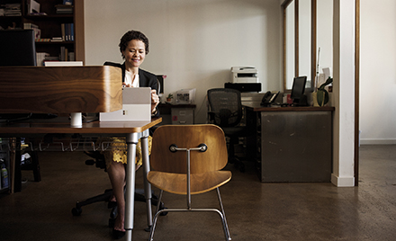 Image of a worker in her office working on a laptop