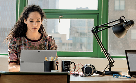 Image of a young small business female with laptop in modern workplace