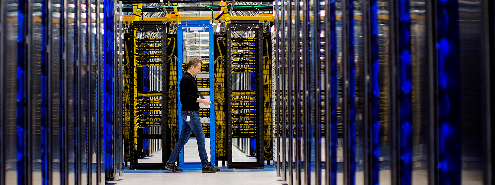 Image of a worker walking amidst servers