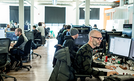 A view of workers using PC stations to perform their duties
