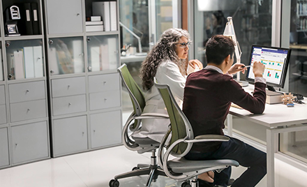Image of two healthcare workers collaborating over a computer