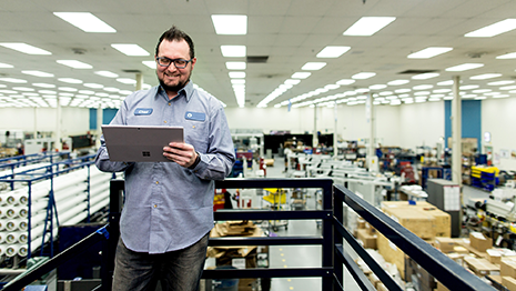 Image of a worker in a warehouse working on a tablet