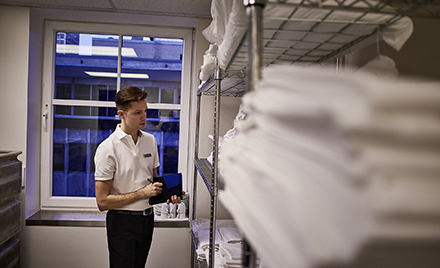 Image of a hotel worker checking supplies in a supply room