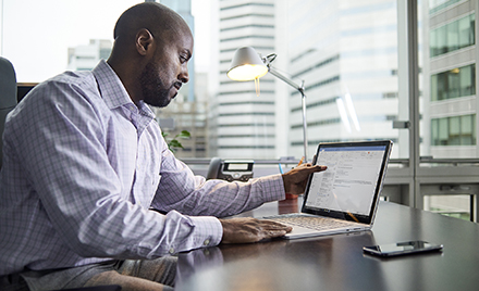 Image of an office worker examining an email on his laptop