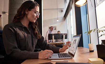 Image of a worker looking at a laptop on her desk