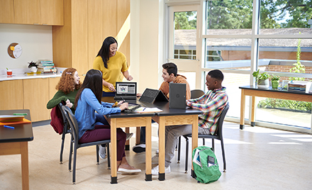 Image of five workers gathered around a table