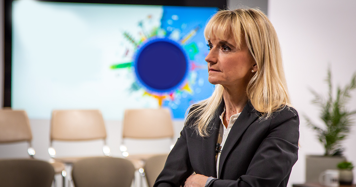 A woman reflects inside a conference room