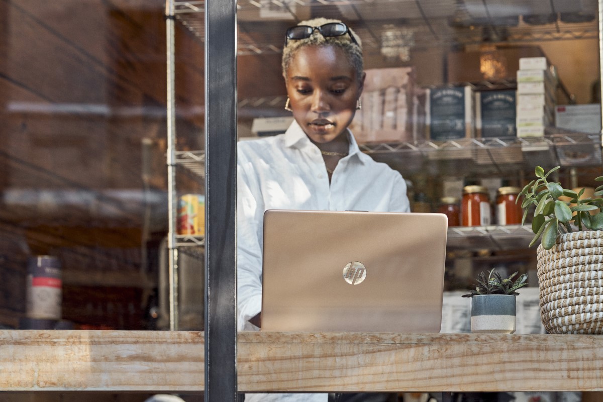 Young woman working on laptop in front of window