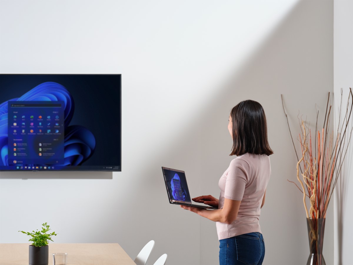 Business person working in hybrid office, displaying Windows 11 start screen