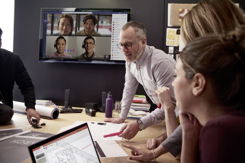 Small medium business employees collaborating using PowerPoint and Microsoft Teams; collaboration; conference room