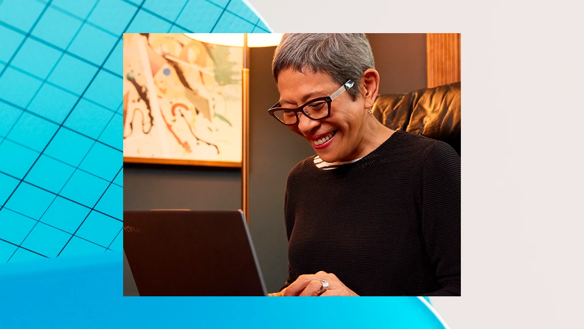 A woman smiling working on a laptop. The image is overlaid on a blue and gray graphic design background