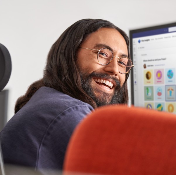 Man smiling while at work, sitting at a computer.